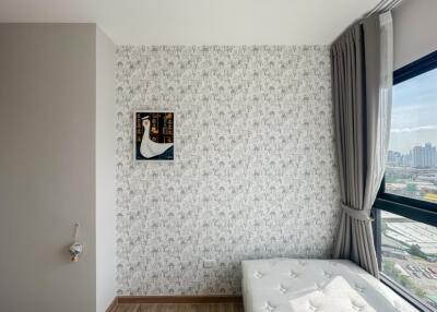 Bright bedroom corner with wallpaper and large window