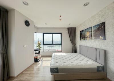 Modern bedroom with large window, bed, and artwork on the wall