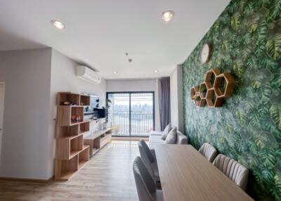 Modern living and dining area with accent wall and natural light