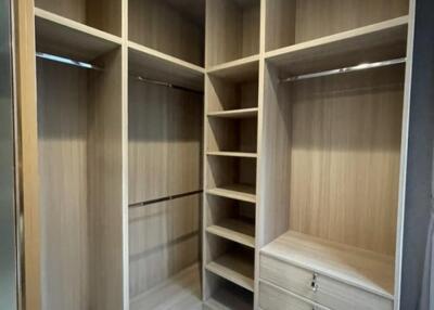 Spacious wooden walk-in closet with shelves and drawers