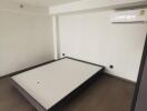 Minimalistic empty bedroom with bed frame and air conditioning