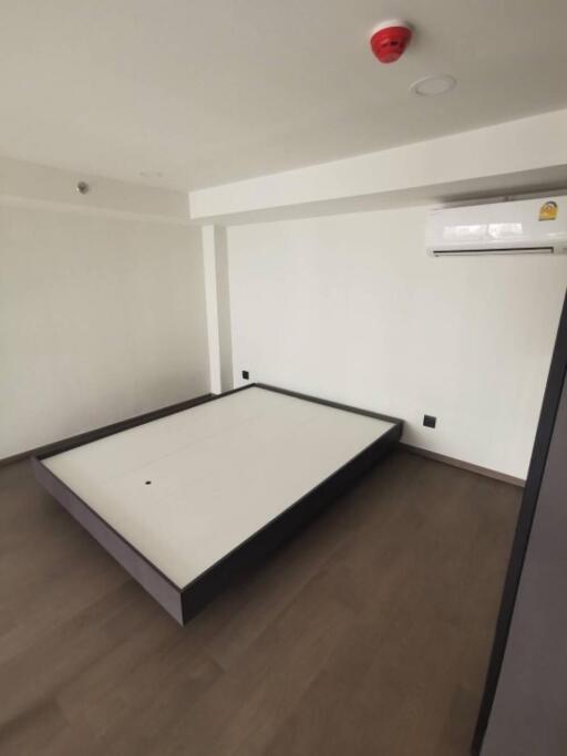 Minimalistic empty bedroom with bed frame and air conditioning