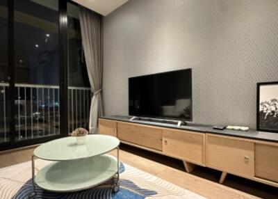 Modern living room with a TV, coffee table, and balcony view