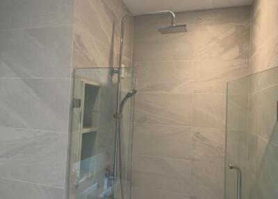 Modern bathroom shower with glass doors and overhead shower head