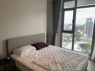 Bright bedroom with a large window offering city views