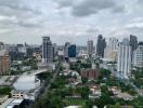 Aerial view of urban skyline with high-rise buildings and lush greenery.