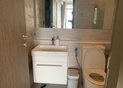 Modern bathroom with sink, toilet, and large mirror