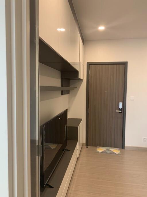 Modern living area with wall-mounted TV storage and entry door