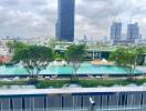 View of a modern cityscape with high-rise buildings, swimming pool, and greenery