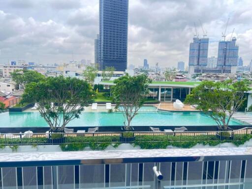 View of a modern cityscape with high-rise buildings, swimming pool, and greenery