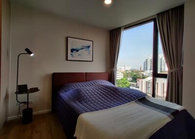 Cozy bedroom with large window and urban view