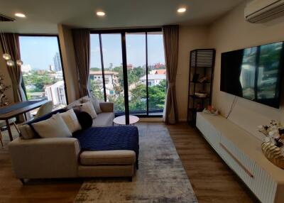 Well-lit living room with large windows and modern furnishings