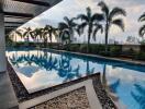 Outdoor pool area with palm trees and city skyline