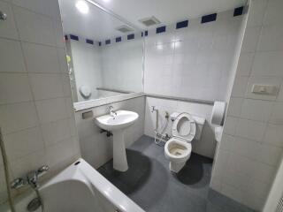 Modern bathroom with bathtub, sink, toilet, and mirror