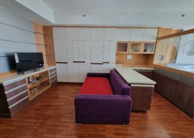 Modern living room with built-in cabinets and a purple sofa