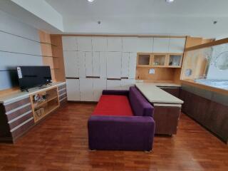 Modern living room with built-in cabinets and a purple sofa