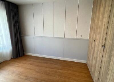 Empty bedroom with wooden floor and built-in wardrobe