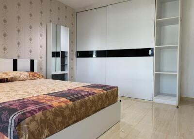 Modern bedroom with bed, wardrobe, and mirror