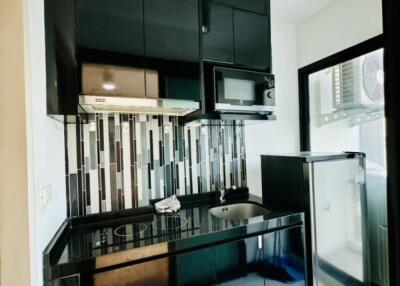 Modern kitchen with black cabinetry and backsplash