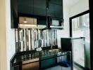 Modern kitchen with black cabinetry and backsplash