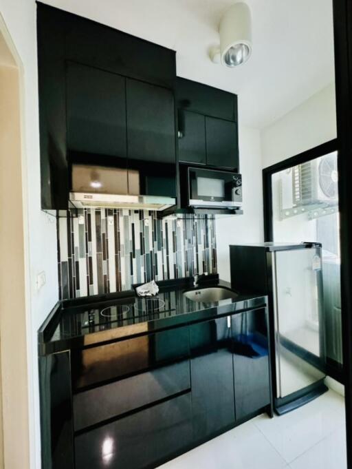 Modern kitchen with black cabinetry and backsplash