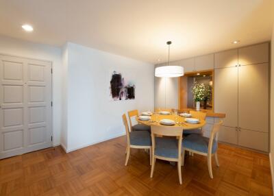 Dining room with wooden floor, modern table, chairs, and decoration