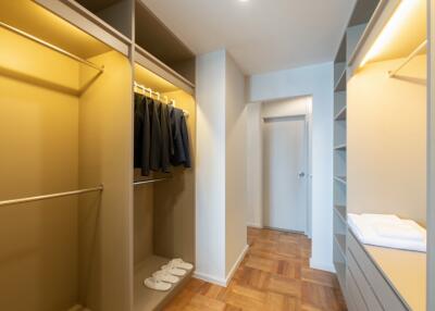 Spacious walk-in closet with wooden floors and ample storage space