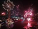 Night view of a city with fireworks over a river