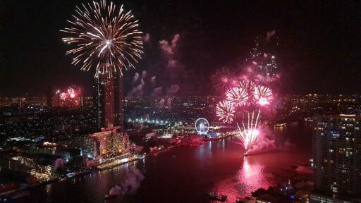 Night view of a city with fireworks over a river