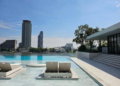 Outdoor pool with lounge chairs and city views