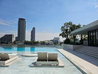 Outdoor pool with lounge chairs and city views