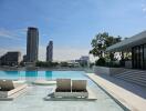 Outdoor pool with lounge chairs and city views