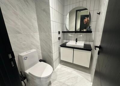 Modern bathroom with a white toilet, sink, and mirror