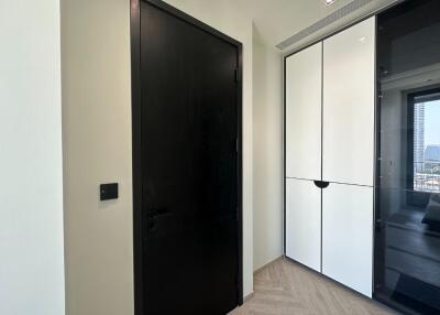 Hallway with black door and white storage cabinets