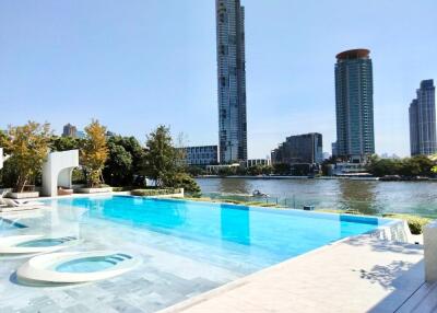 Outdoor pool area with a view of high-rise buildings and river
