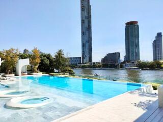 Outdoor pool area with a view of high-rise buildings and river