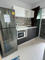 Modern kitchen with mosaic backsplash, stainless steel fridge, built-in microwave, and sliding glass doors