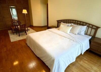 Spacious bedroom with wooden floors and a cozy bed