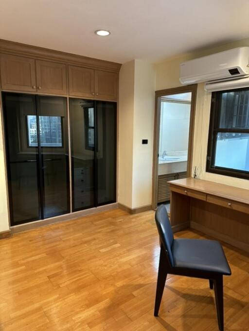 Bedroom with wooden floor, built-in wardrobe, and desk with chair