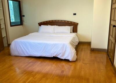 Spacious bedroom with wooden floor and double bed