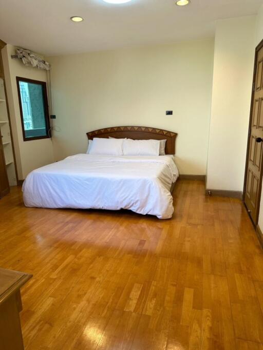 Spacious bedroom with wooden floor and double bed