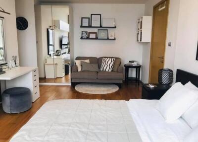 Modern bedroom with a cozy seating area and wall-mounted shelves