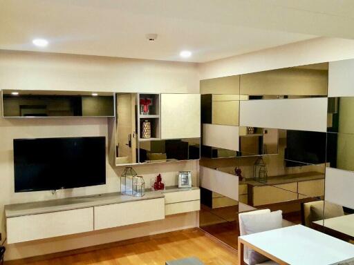 Modern living room with wall-mounted TV and decorative mirrors