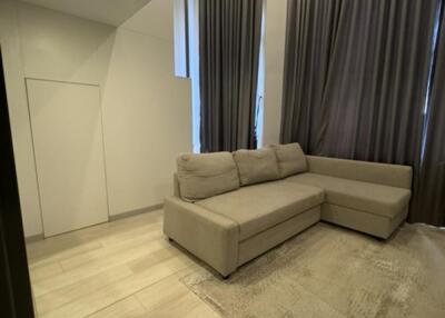 Modern living room with a beige sectional sofa and tall curtains