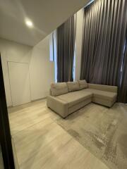 Modern living room with a beige sectional sofa and tall curtains