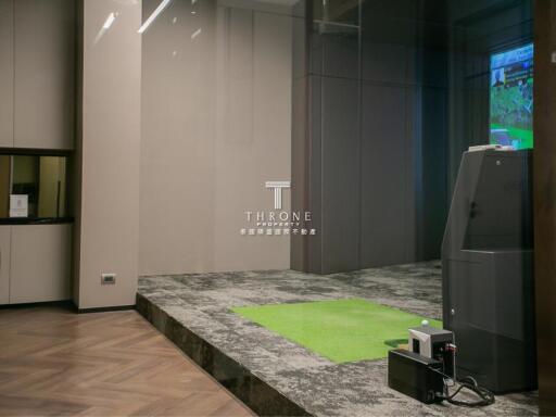 Modern indoor entertainment area with large screen and golf simulation setup