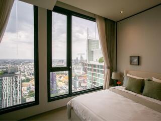 Modern bedroom with a large window offering a city view