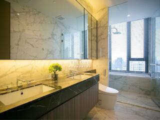 Modern bathroom with double sinks, large mirror, and a spacious bathtub