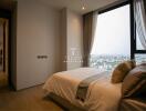 Modern bedroom with a large window and city view