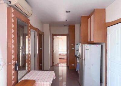 Small kitchen adjacent to a hallway leading to a bedroom